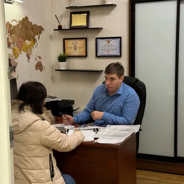 Юрист «Правового Эксперта» разбирает документы клиента на консультации